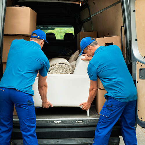 Equipo cargando un sofá en el vehículo de mudanzas
